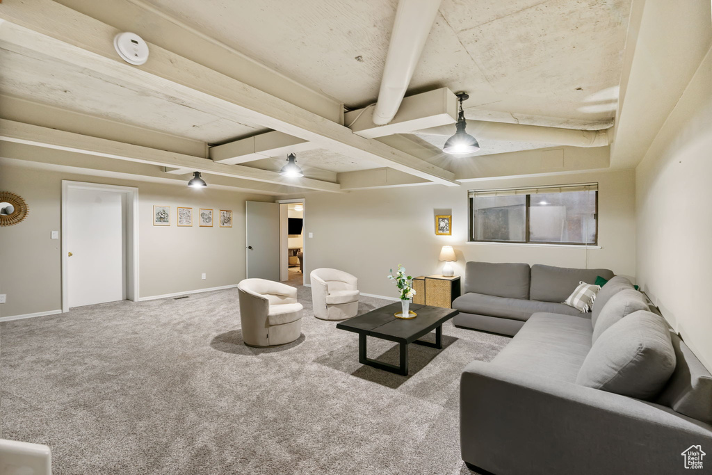 Carpeted living area with baseboards and beam ceiling