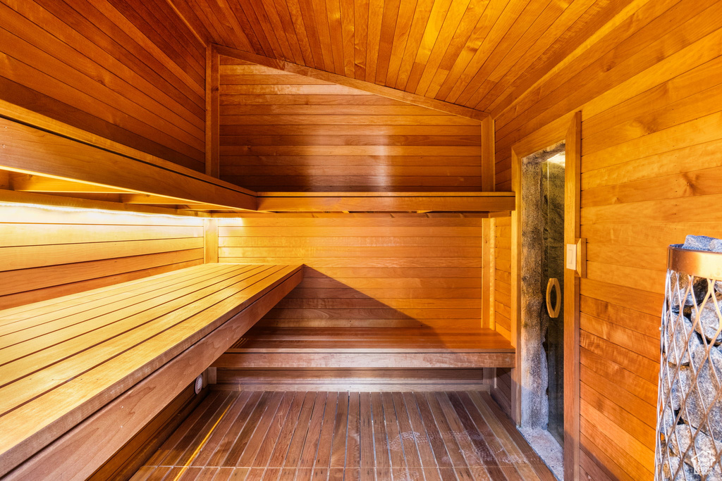 Relaxing sauna featuring wood walls and wooden ceiling