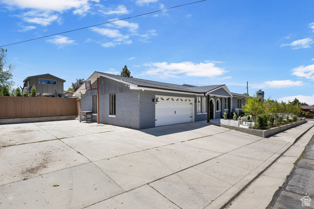 Single story home with concrete driveway, brick siding, and a garage