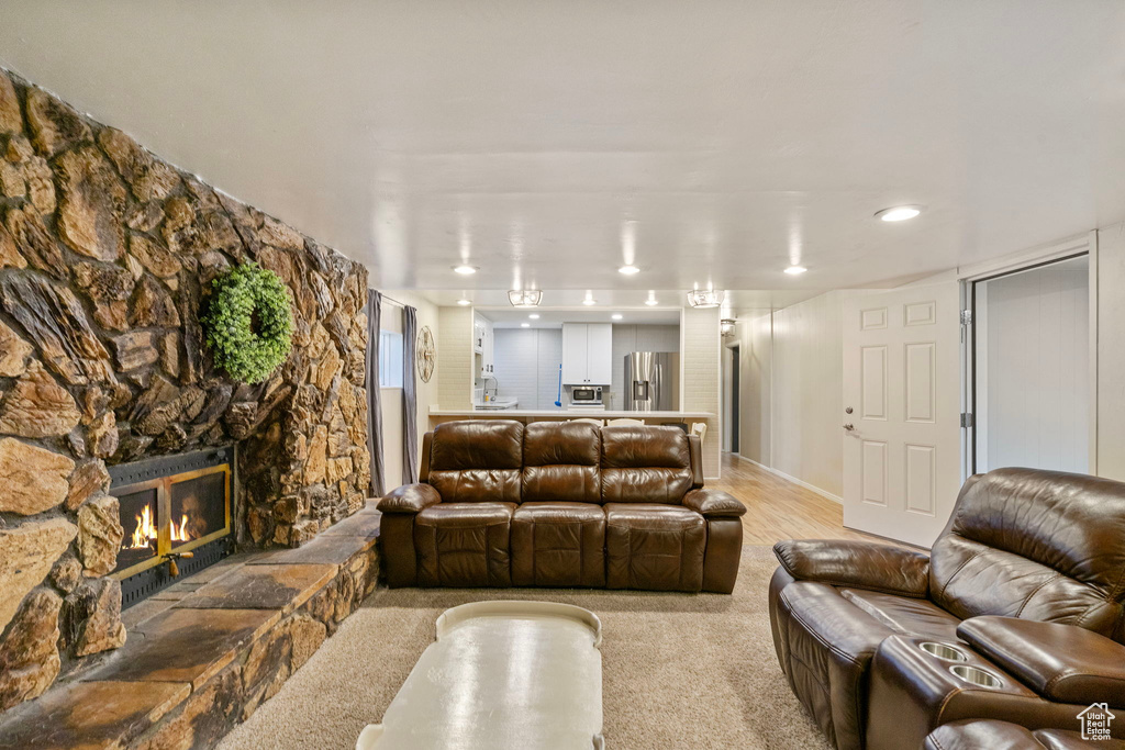 Living room with a fireplace, recessed lighting, and light carpet
