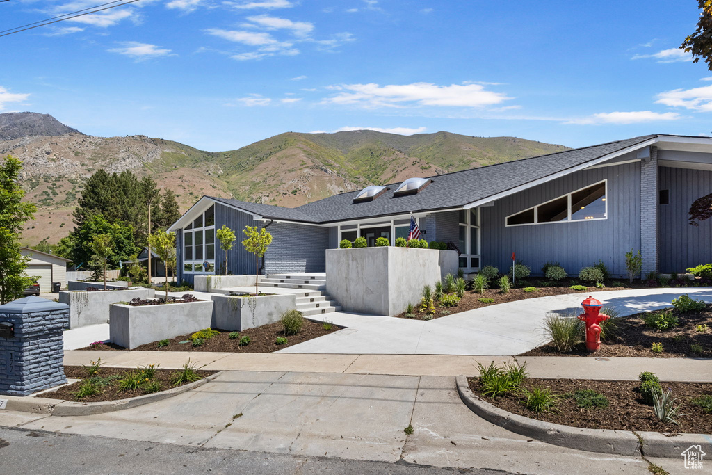 View of front of home featuring a mountain view and driveway