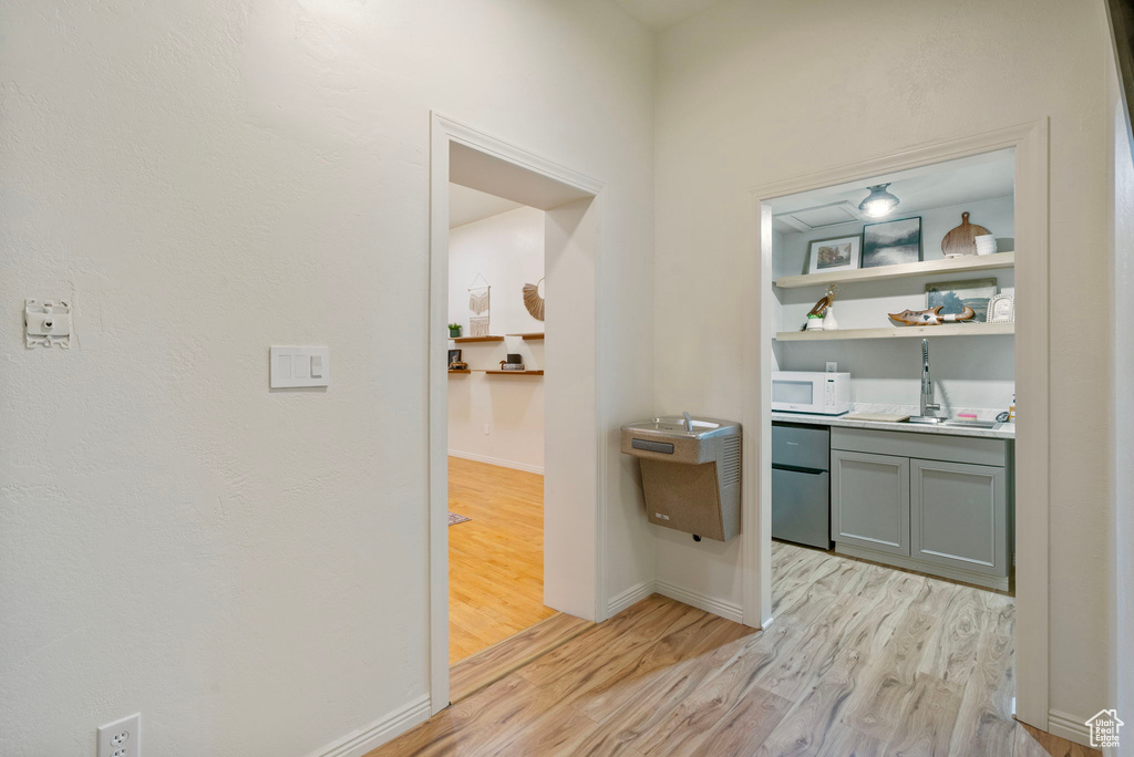 Hall with light wood finished floors and baseboards