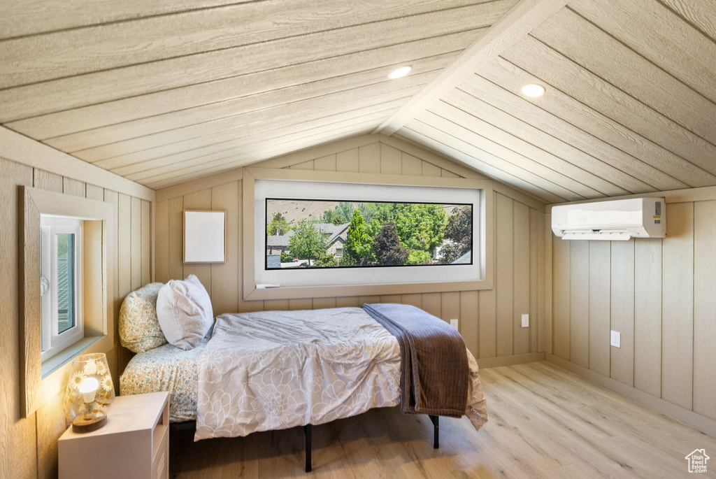Bedroom with an AC wall unit, wood finished floors, vaulted ceiling, recessed lighting, and wooden walls