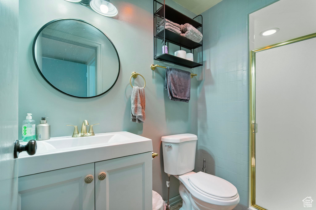 Full bath featuring toilet, a stall shower, and vanity