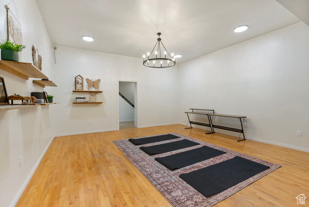 Interior space featuring wood finished floors, a chandelier, baseboards, and recessed lighting