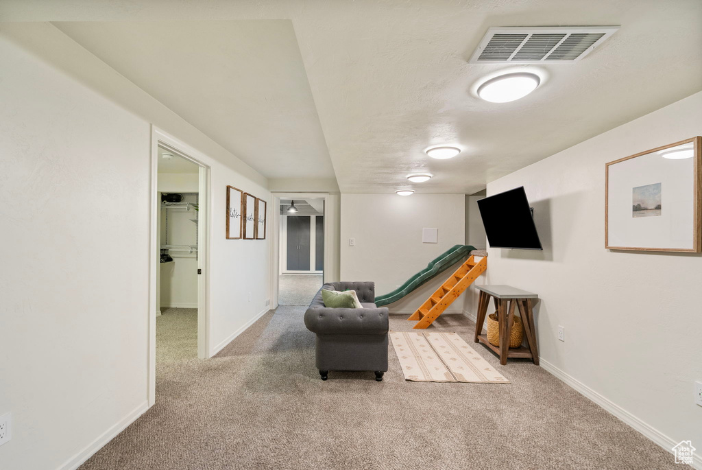Living area featuring carpet flooring and baseboards