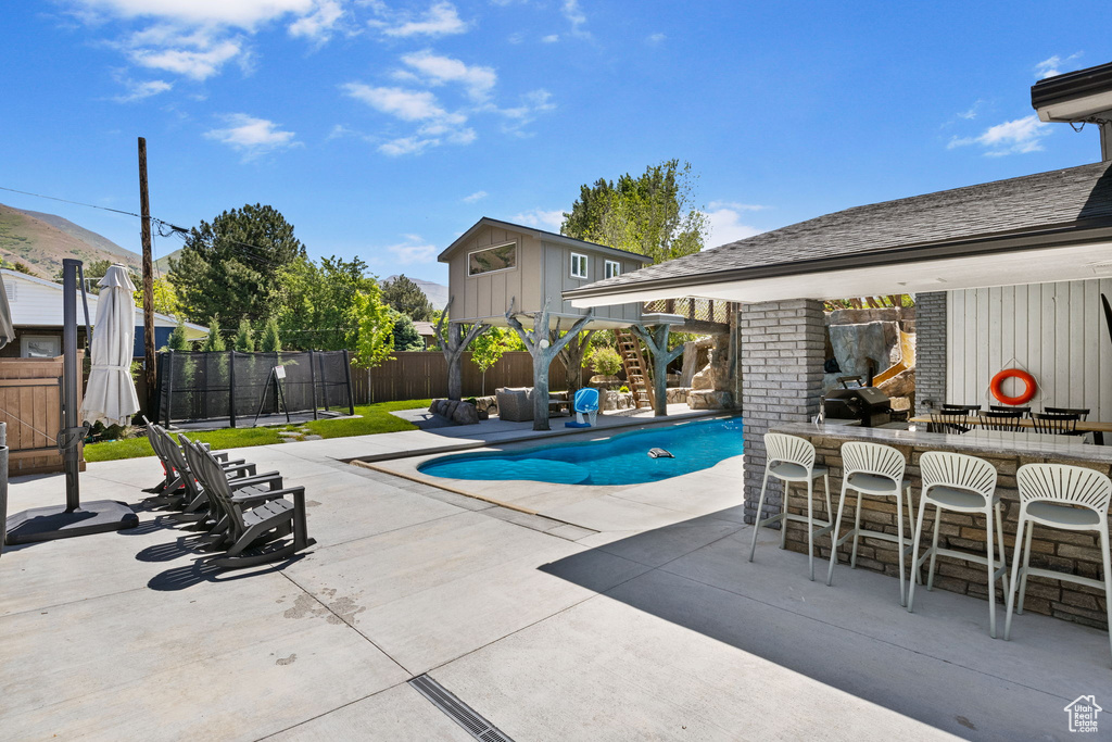 View of swimming pool featuring a patio and a fenced backyard