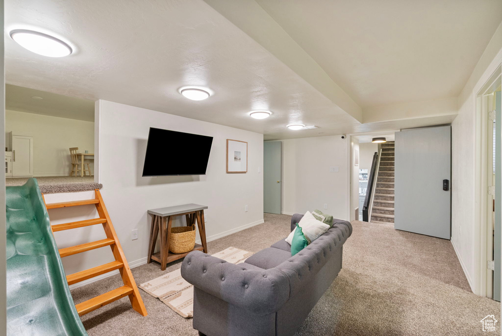 Living room featuring stairway, light colored carpet, and baseboards