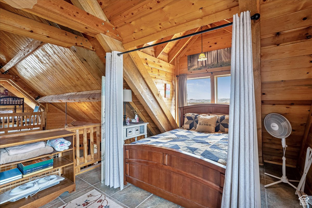 Bedroom with vaulted ceiling, wooden walls, and wood ceiling