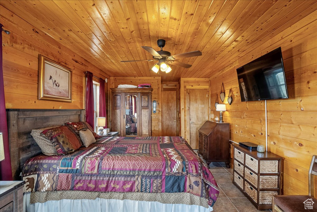 Tiled bedroom featuring wood walls and wooden ceiling