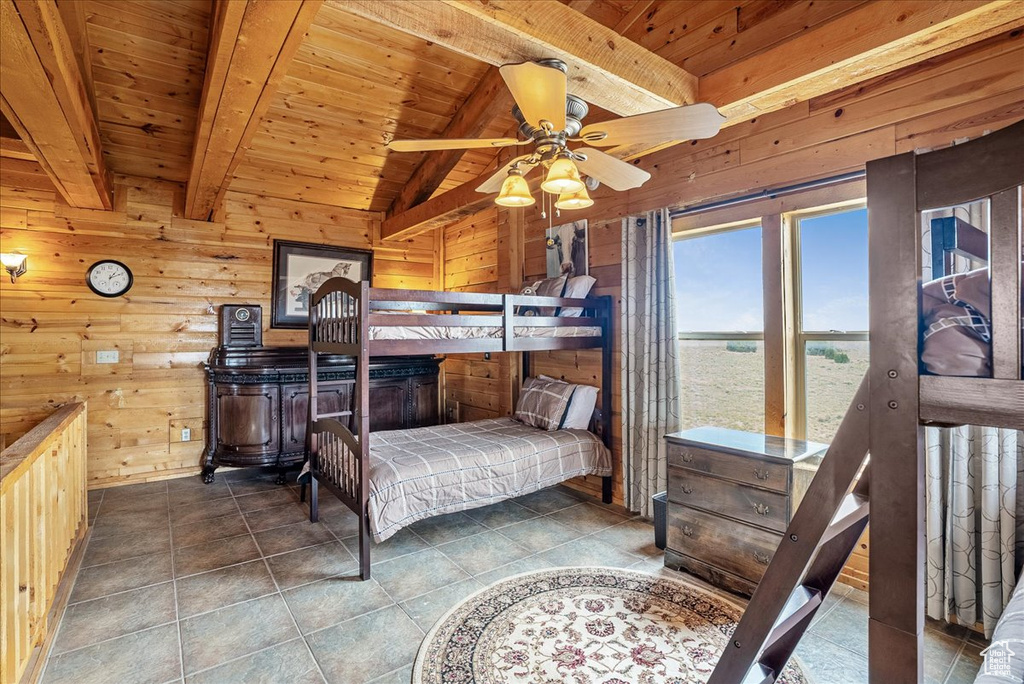 Bedroom with wooden ceiling, wood walls, and tile patterned flooring