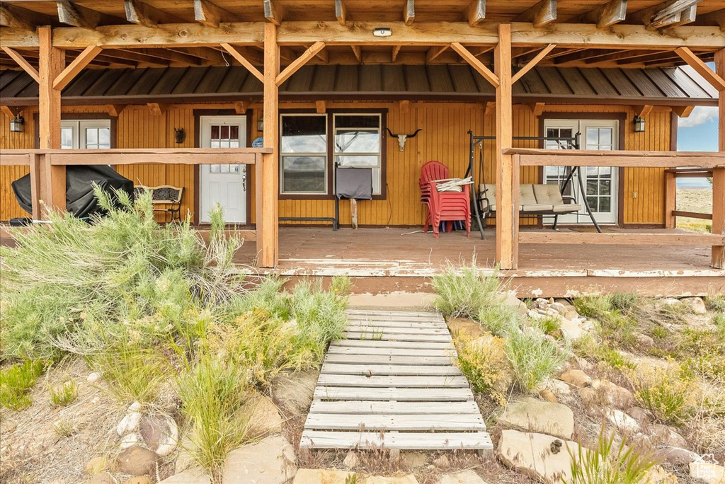Property entrance with covered porch and metal roof