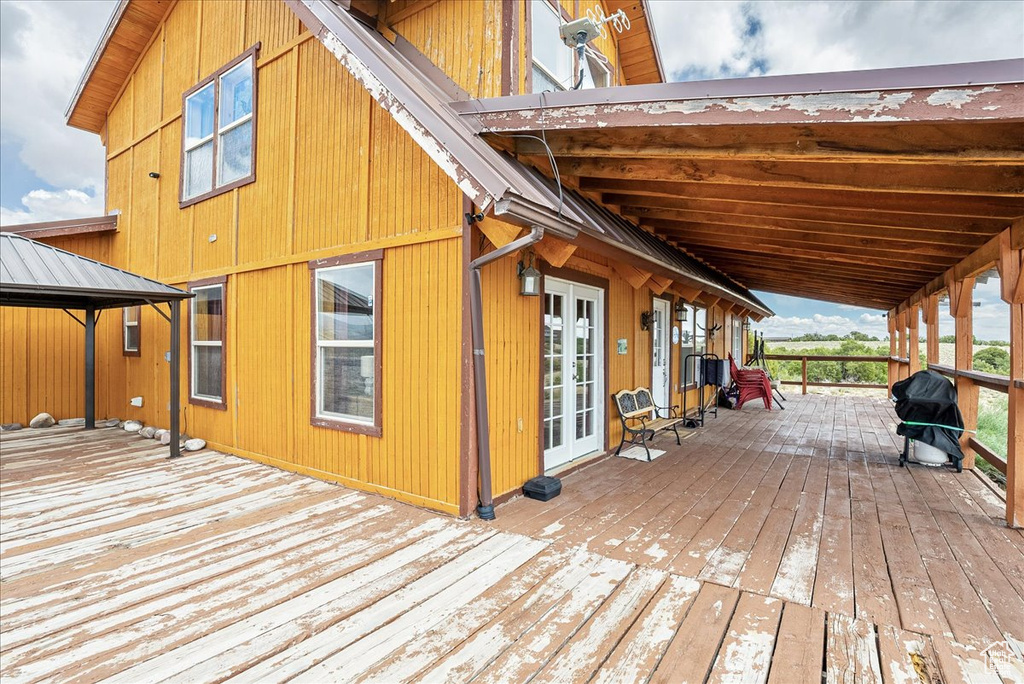 Wooden deck with a gazebo, a grill, and french doors