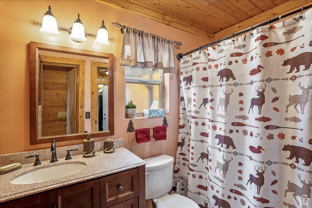 Bathroom featuring wooden ceiling, toilet, vanity, and a shower with curtain