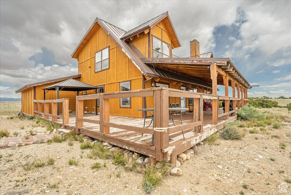 Back of property with metal roof and a deck