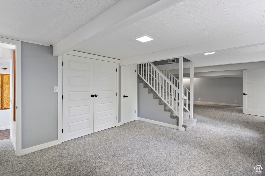 Finished basement featuring carpet, stairs, and baseboards
