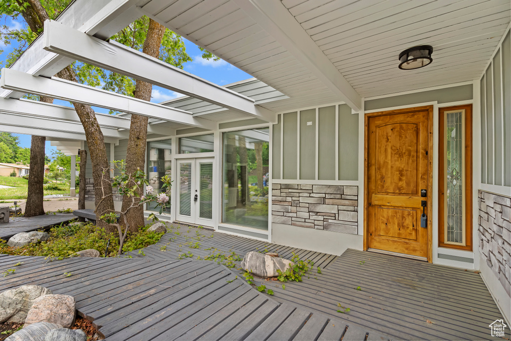 Entrance to property with board and batten siding, french doors, and stone siding
