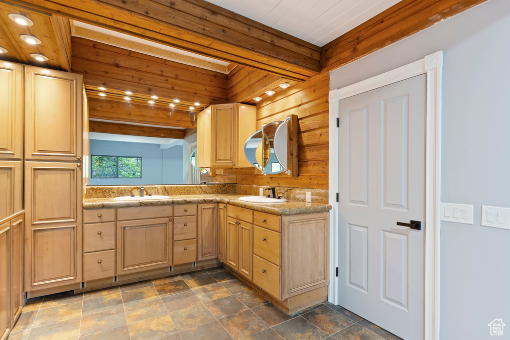 Bathroom with double vanity, wood walls, stone finish flooring, and wooden ceiling