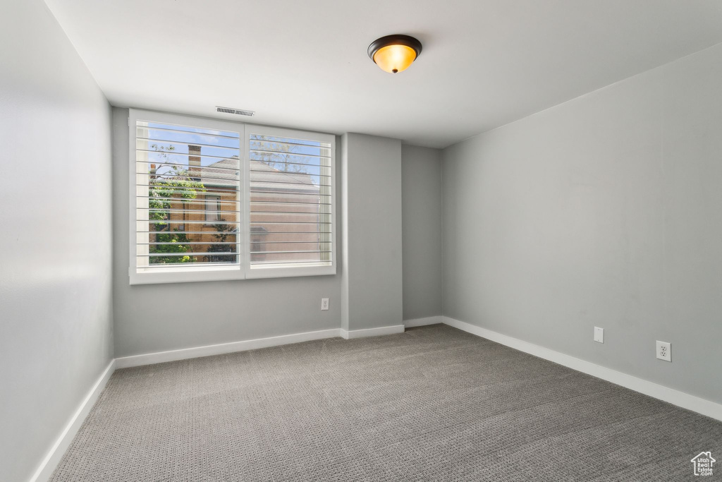 Carpeted spare room with baseboards