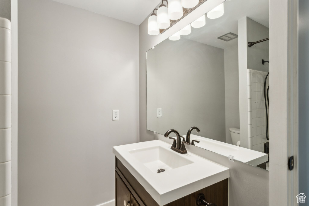 Full bath with vanity, toilet, and a shower