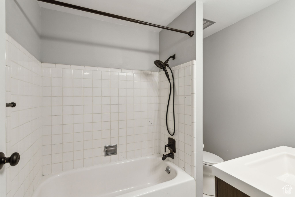 Bathroom featuring toilet, vanity, and shower / washtub combination