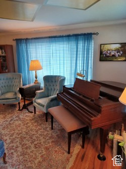 Living area with wood finished floors and ornamental molding