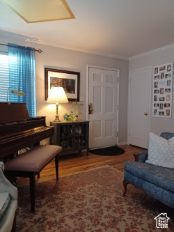 Sitting room featuring wood finished floors and crown molding