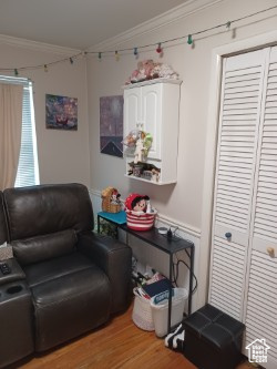 Living area with ornamental molding and light wood-style floors