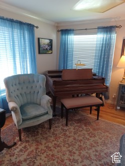 Living area featuring crown molding and wood finished floors