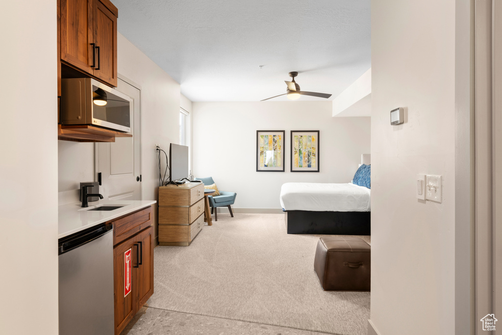 Bedroom featuring light carpet, a sink, and baseboards