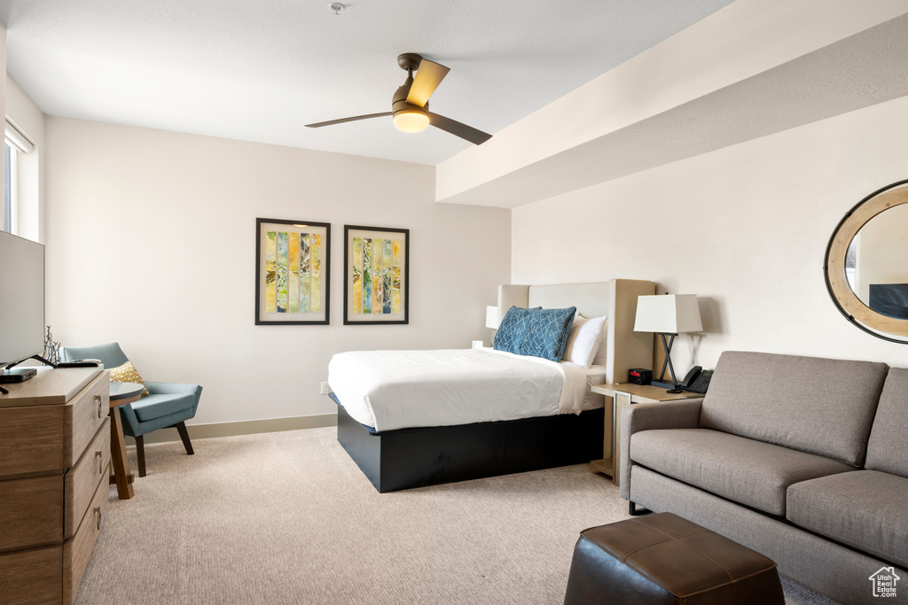 Bedroom featuring light carpet, baseboards, and a ceiling fan