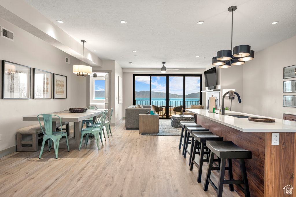 Dining area with a chandelier, light wood-style floors, baseboards, recessed lighting, and ceiling fan