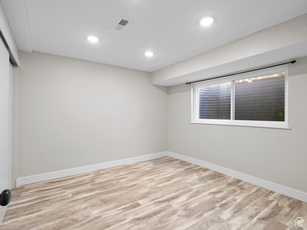 Spare room with light wood-type flooring, baseboards, and recessed lighting