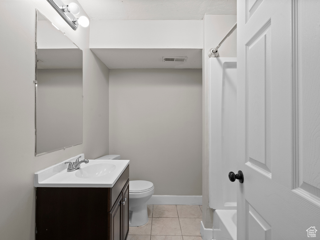 Bathroom featuring vanity, tile patterned floors, toilet, shower / bath combination, and baseboards