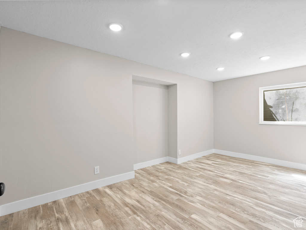Spare room with light wood-style flooring, baseboards, and recessed lighting