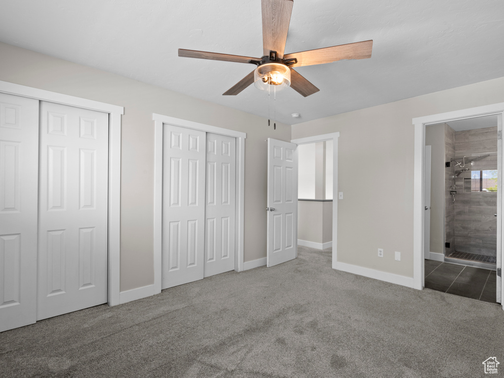 Unfurnished bedroom with multiple closets, carpet floors, baseboards, and ensuite bath