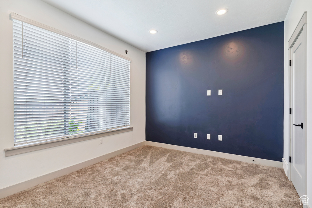 Carpeted empty room featuring recessed lighting and baseboards