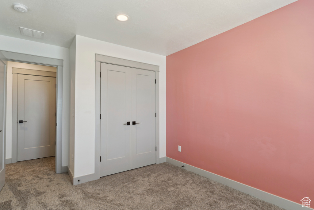 Unfurnished bedroom with baseboards, carpet floors, recessed lighting, and a closet