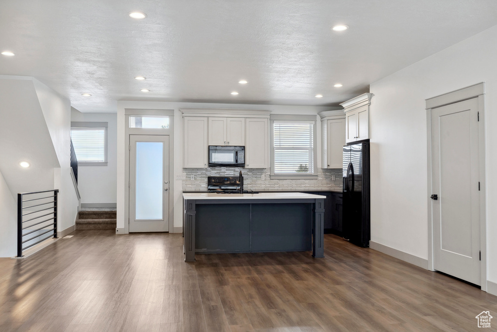 Kitchen with black appliances, baseboards, healthy amount of natural light, and recessed lighting