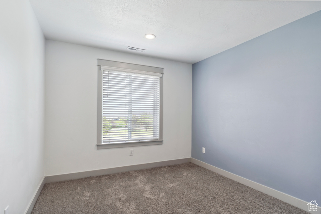 Carpeted spare room with baseboards