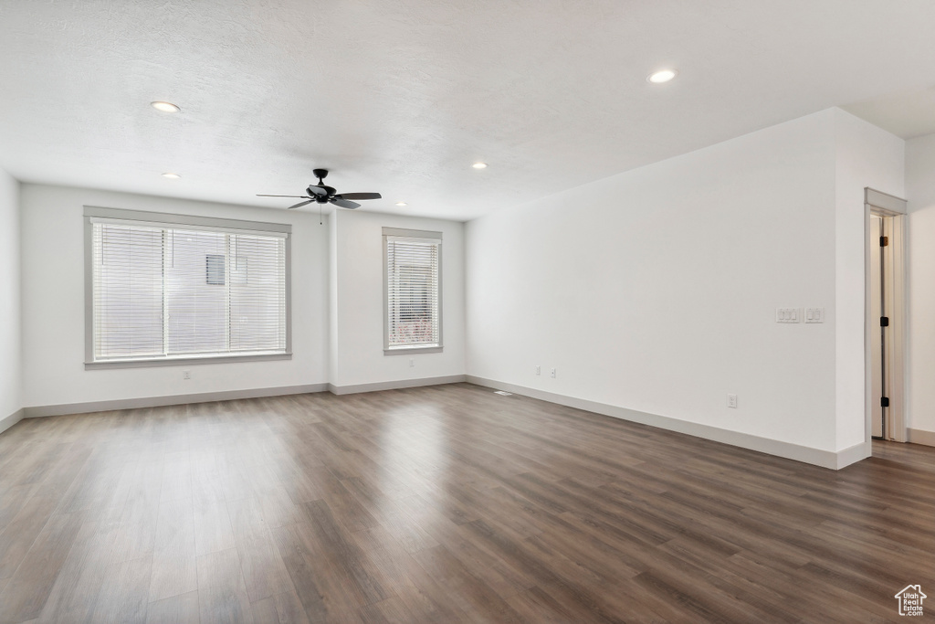 Unfurnished living room with wood finished floors, baseboards, a ceiling fan, and recessed lighting