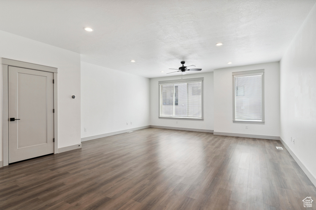 Unfurnished living room with ceiling fan, wood finished floors, baseboards, and recessed lighting