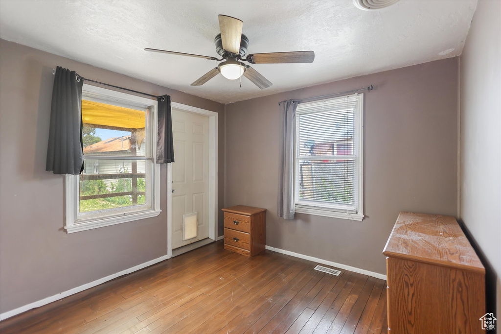 Unfurnished bedroom featuring baseboards, hardwood / wood-style flooring, and a ceiling fan