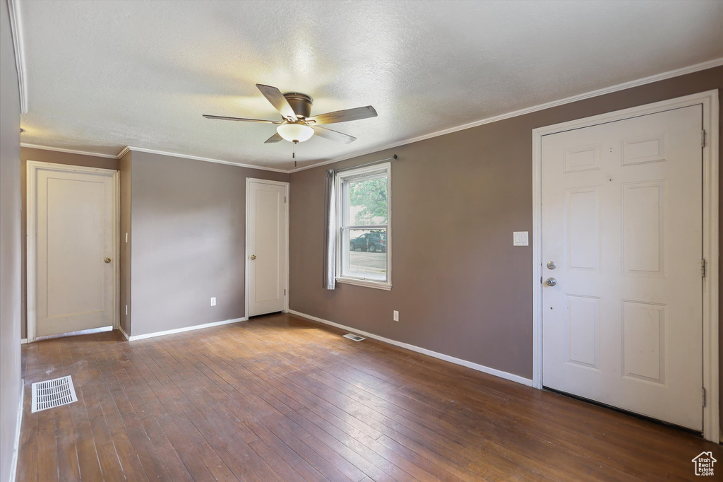 Foyer with a ceiling fan, baseboards, hardwood / wood-style floors, and ornamental molding