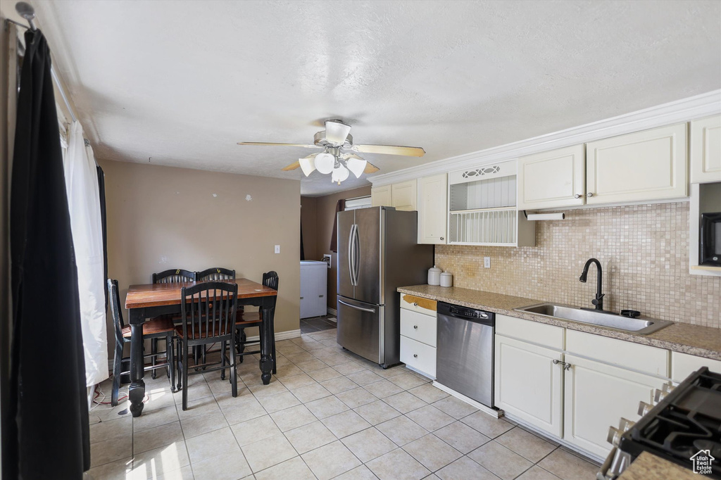Kitchen with a sink, appliances with stainless steel finishes, light countertops, and light tile patterned floors