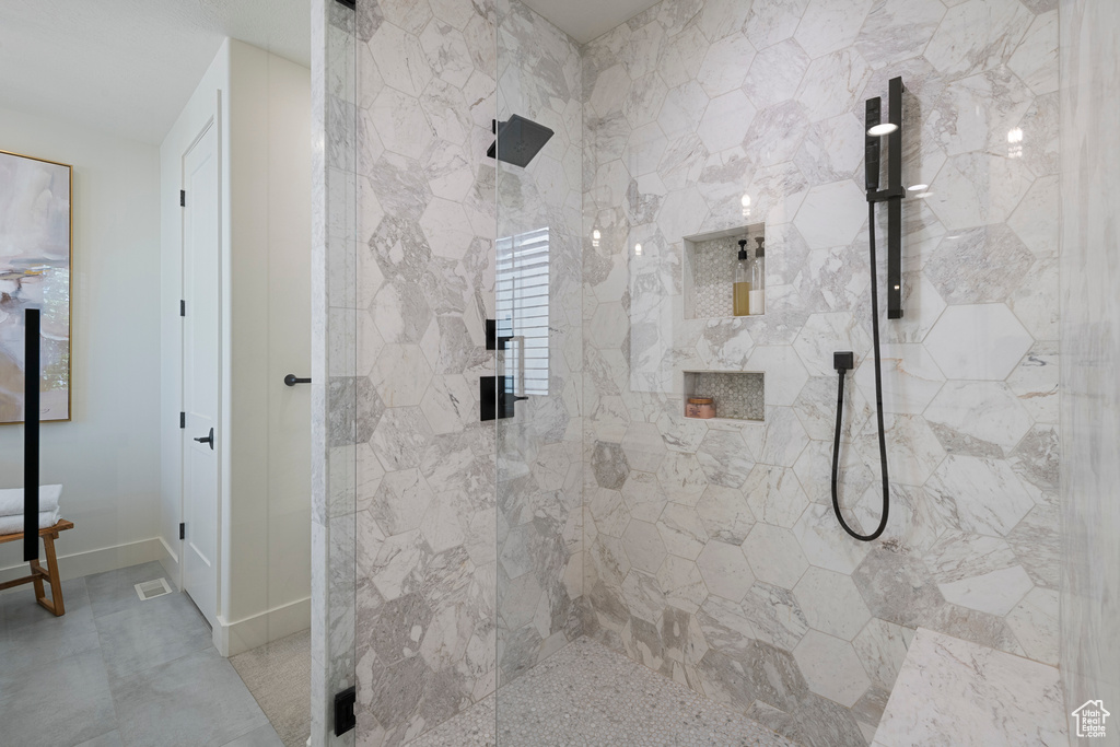 Full bathroom featuring a stall shower and baseboards