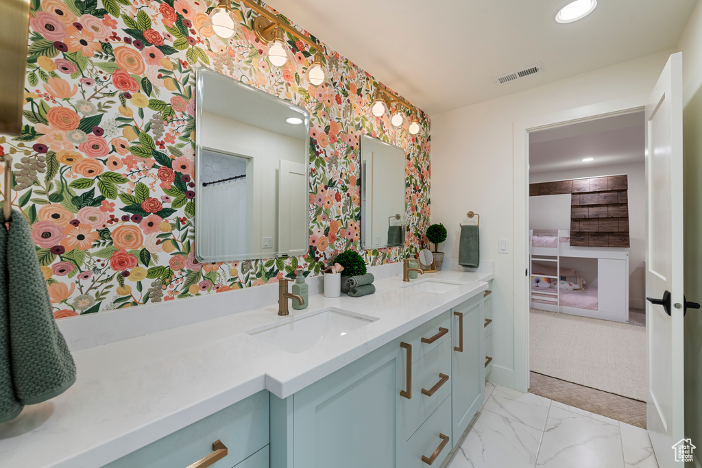 Bathroom with double vanity, recessed lighting, wallpapered walls, and marble finish flooring