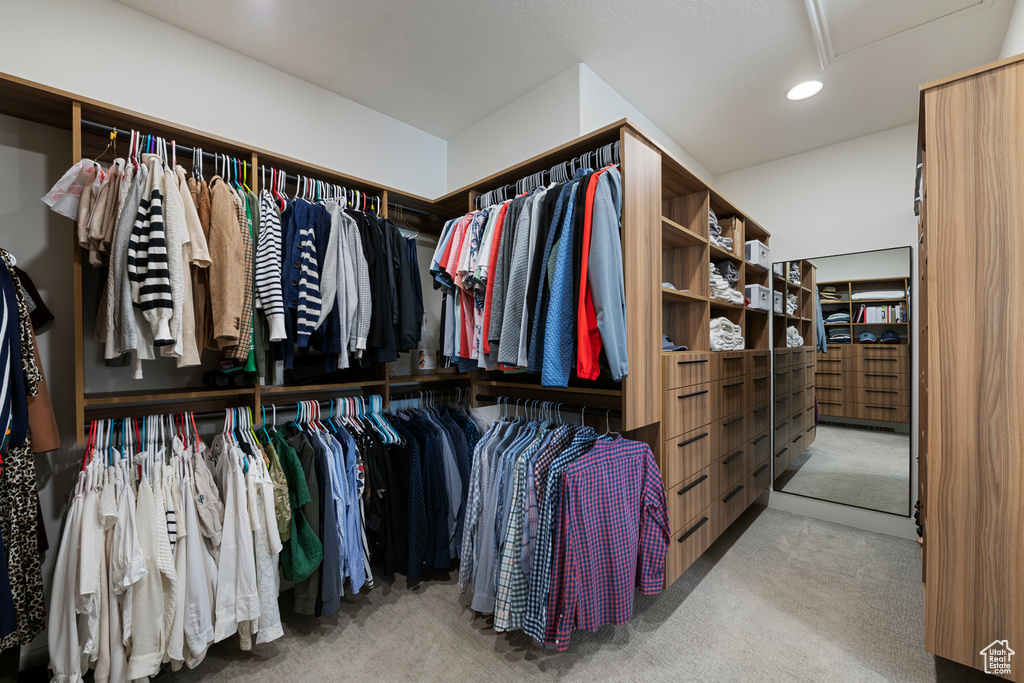 Walk in closet with carpet flooring and attic access