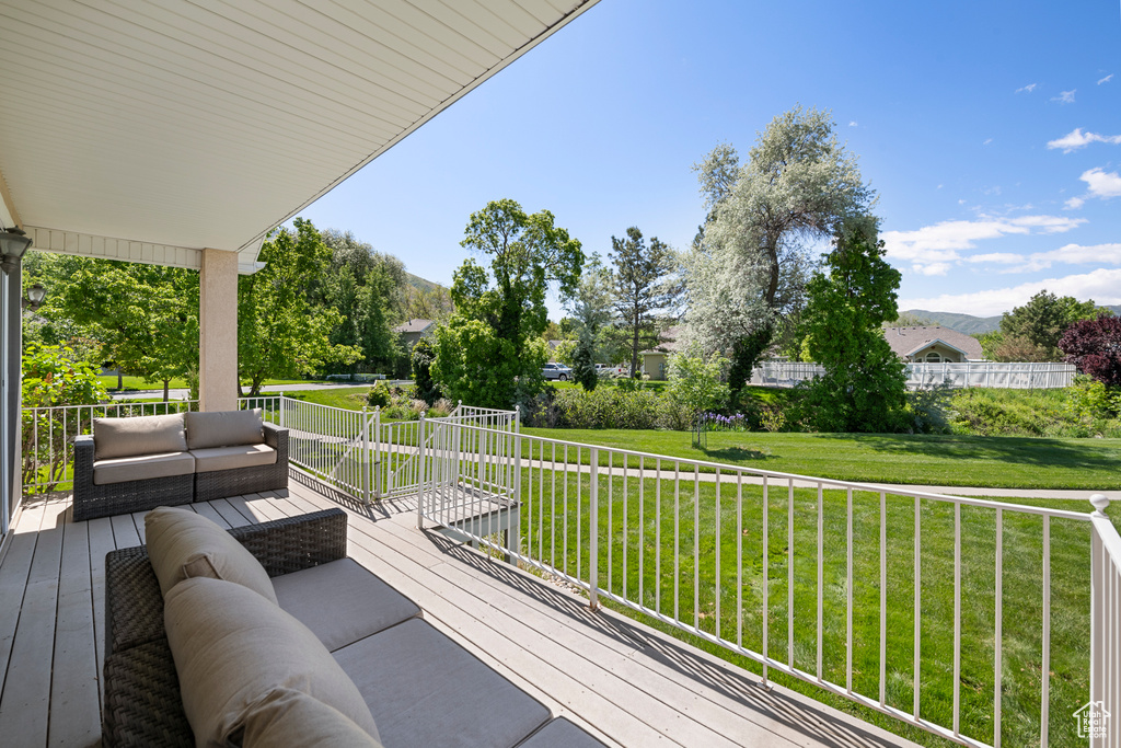 Deck featuring outdoor lounge area, a lawn, and a mountain view