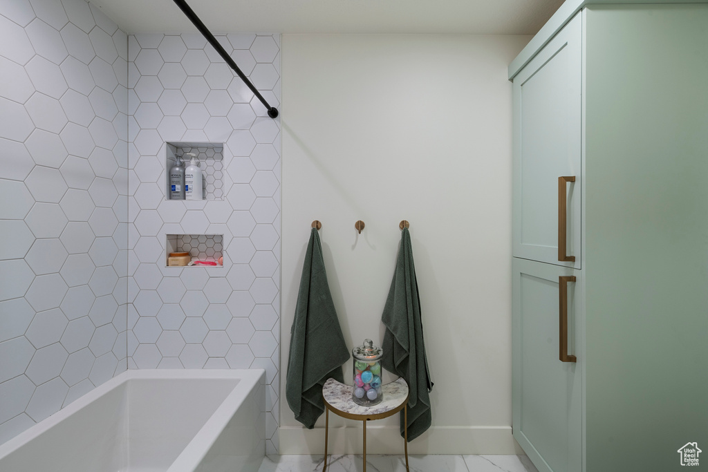 Full bath with baseboards and washtub / shower combination